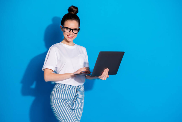 Portrait of nice attractive pretty skilled cheerful girl copywriter hr manager consultant agent broker holding in hand using laptop isolated on bright vivid sine vibrant blue color background - Zdjęcie, obraz