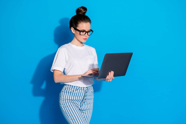 Portrait of nice attractive pretty smart clever skilled focused girl holding in hand laptop part-time e-banking e-commerce occupation isolated on bright vivid sine vibrant blue color background - Photo, Image