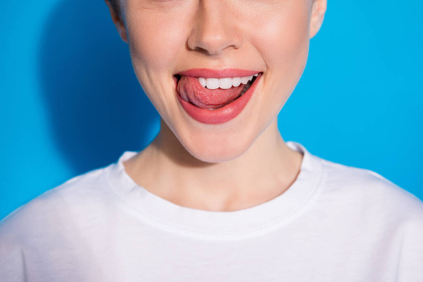 Cropped close-up portrait of her she nice attractive healthy playful cheerful cheery girl licking lip caries therapy treatment isolated on bright vivid sine vibrant blue color background - Foto, afbeelding
