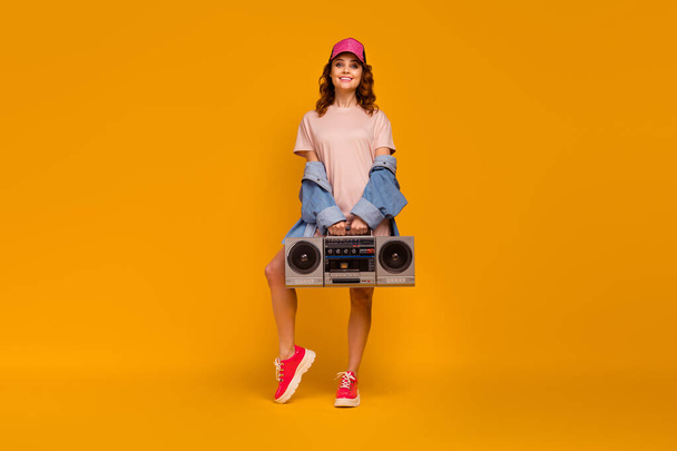 Full length body size view of her she nice attractive lovely fashionable cheerful cheery girl wearing cool look carrying boombox isolated on bright vivid shine vibrant yellow color background - 写真・画像