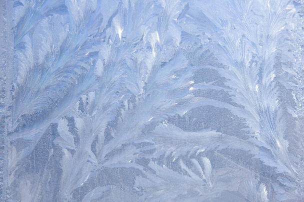 Красивый крупным планом Зимнее окно с покрытием блестящий ледяной лед узоры - Фото, изображение