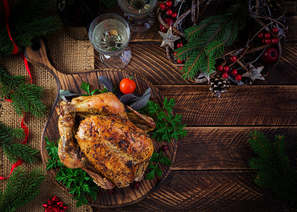 Pavo al horno o pollo. La mesa de Navidad se sirve con un pavo, decorado con oropel brillante. Pollo frito, mesa. Cena de Navidad. Vista superior, techo, espacio para copiar - Foto, Imagen