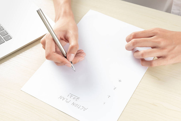 A hand of businesswoman writing on paper in the office - Photo, Image