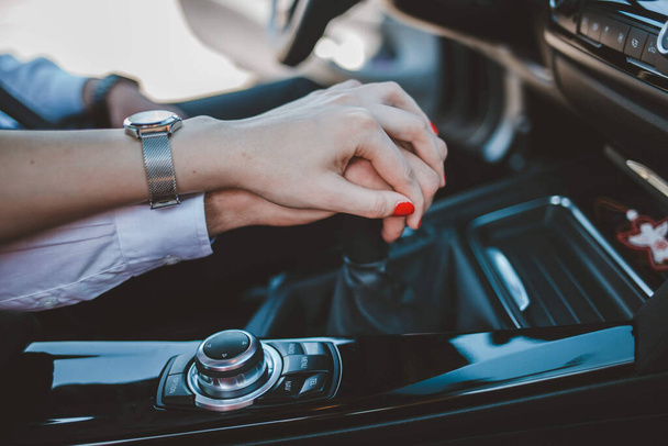 A closeup shot of a woman's hand on top of the man's hand in the car - love concept - Fotoğraf, Görsel