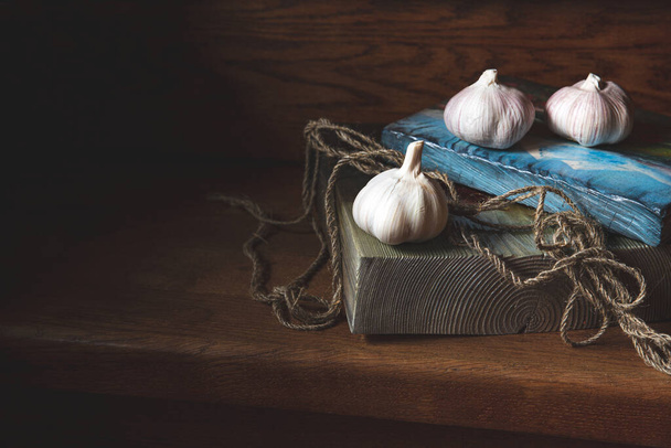Beautiful still life on a wooden staircase, painting.Garlic, jute rope on wooden boards.Daylight, selective focus. Place for text.Conceptual, vintage - Fotografie, Obrázek