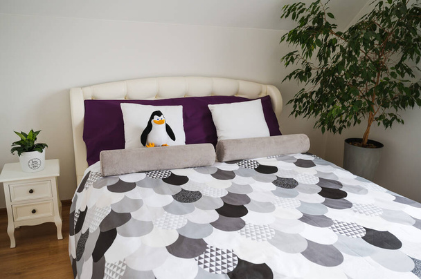 Pluszowy pingwin na łóżku w sypialni - Zdjęcie, obraz