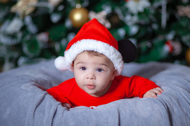 Bambino carino che indossa il vestito di Babbo Natale vicino all'albero di Natale, Capodanno - Foto, immagini