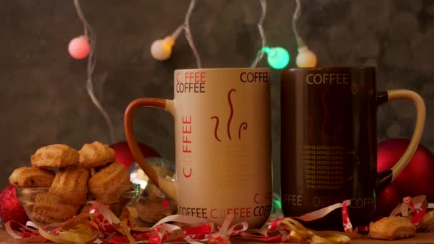ボケのライトの装飾が施されたクリスマスコーヒーカップ。冬の休日の音楽の背景、居心地の良い家庭の良い朝のコンセプト、新年のお祝いの歌。熱いお茶を飲む2つのマグカップ。恋愛カップルデート. - 映像、動画