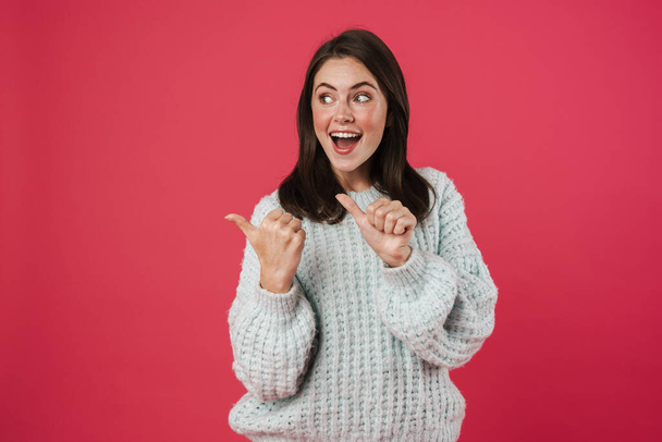 Image of excited beautiful girl pointing fingers aside isolated over pink background - Фото, зображення