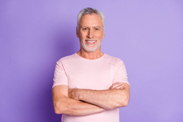 Photo of self-assured grandfather crossed hands toothy smile wear pink t-shirt isolated violet color background - Fotoğraf, Görsel