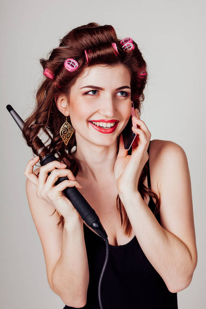 Gyönyörű nő készíti haj fürtök csavarja haj - Fotó, kép