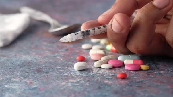 concetto di tossicodipendenza con pacchetto di eroina e siringa su sfondo nero  - Filmati, video