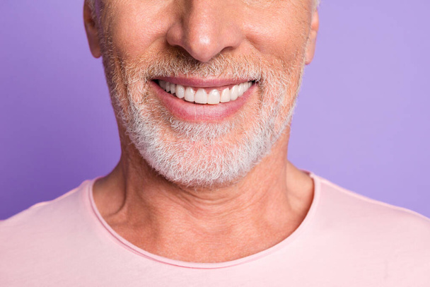 Cropped photo of pensioner old bristled man white beaming toothy smile wear pink t-shirt isolated purple color background - Fotó, kép