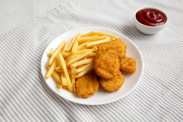 Lezzetli Fast food: Tavuk nugget ve patates kızartması kumaş tabakta, düşük açılı görünüm.  - Fotoğraf, Görsel