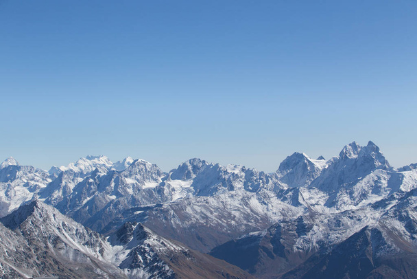 Cime innevate della catena montuosa del Caucaso contro un cielo blu. - Foto, immagini