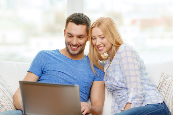 Smiling happy couple with laptop at home - Foto, Imagen