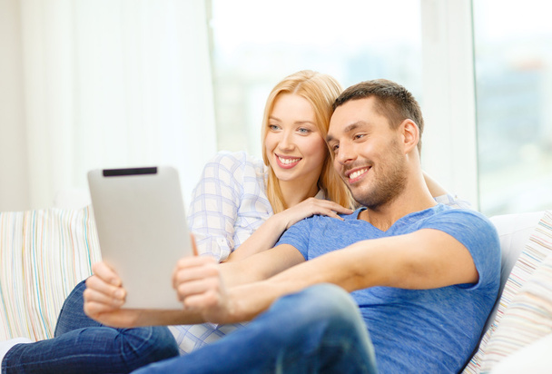Smiling happy couple with tablet pc at home - Photo, image