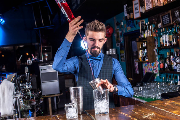 Charming barman demonstrates the process of making a cocktail at the nightclub - Photo, Image