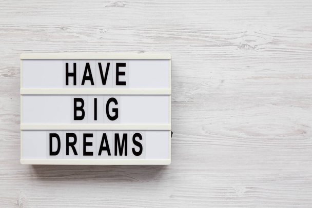 'Have Big Dreams' on a lightbox on a white wooden background, top view. Flat lay, overhead, from above. Copy space. - Photo, Image