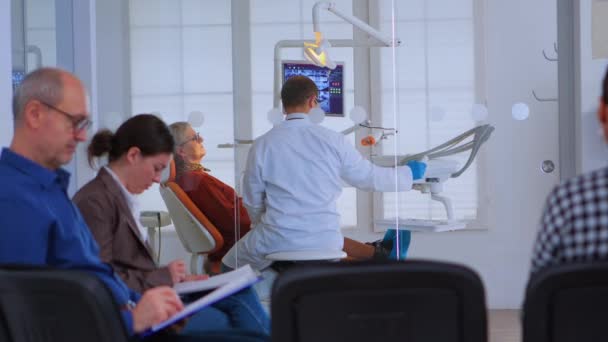 Médecin dentiste travaillant dans un bureau bondé - Séquence, vidéo