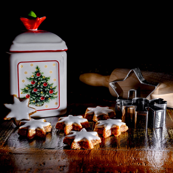 Різдвяна сцена з зірками кориці, формами печива, прокатним штифтом та керамічним олов'яним печивом на старому дерев'яному столі
. - Фото, зображення