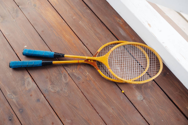 Badminton rackets lie on the wooden veranda - Photo, Image