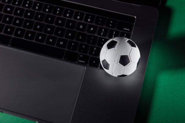 Voetbal op een laptops toetsenbord. Sport, gokken, geld winnen concept - Foto, afbeelding