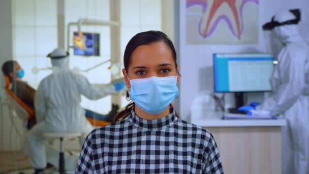 Portret van vrouw met masker in tandheelkundig kantoor op zoek naar camera - Video