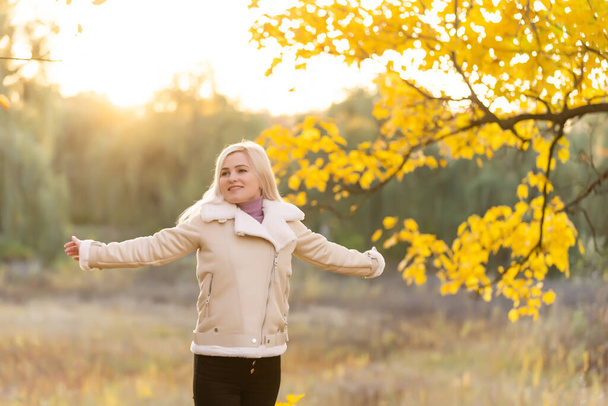 Bella donna elegante in piedi in un parco in autunno, concetto di caduta - Foto, immagini