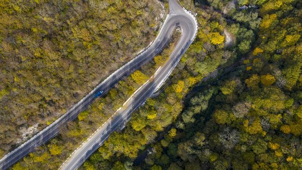 Smountain road along the sea, aerial vieweaside resort, Serpentine, aerial view of road along seaside of island with forest autumn on hill side back ground. - Foto, afbeelding