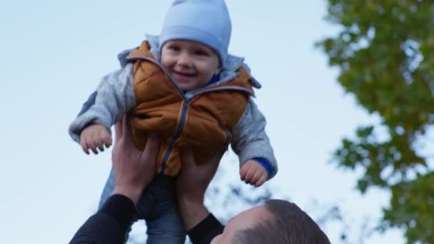 vaderschap, liefhebbende man spelen met zoon buiten, vader lift in de lucht zijn kind jongen op de achtergrond van de hemel - Video