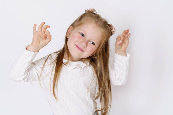 Children concept. The girl shows the gesture ok. Isolated over white background. - 写真・画像