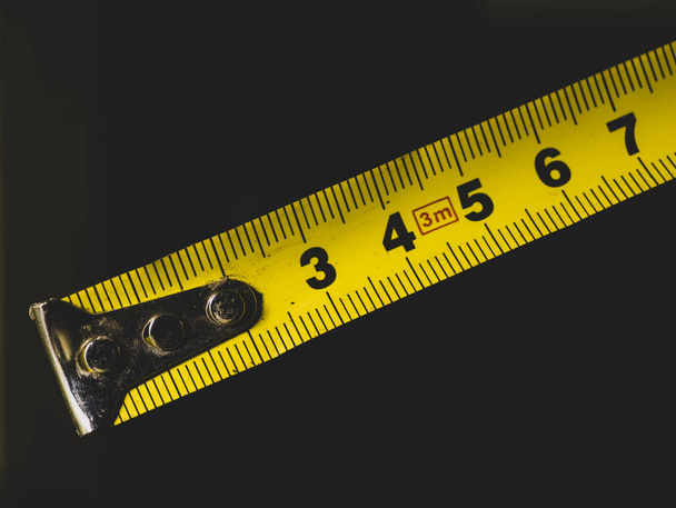 Unwound yellow tape measure. Dial, black numbers on a yellow background. - Φωτογραφία, εικόνα