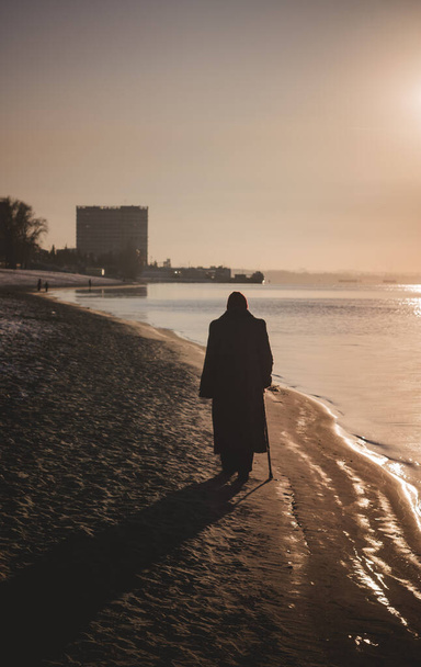 Der alte Mann geht am Ufer entlang. Wintersonnenuntergang an der Wolga. - Foto, Bild