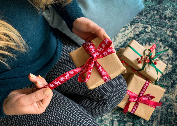 View above blond woman unboxing christmas presents. - Фото, зображення