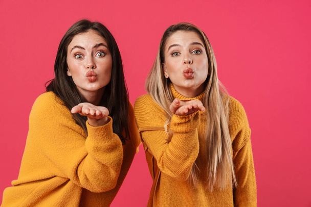 Image of excited beautiful women blowing air kisses at camera isolated over pink background - Φωτογραφία, εικόνα