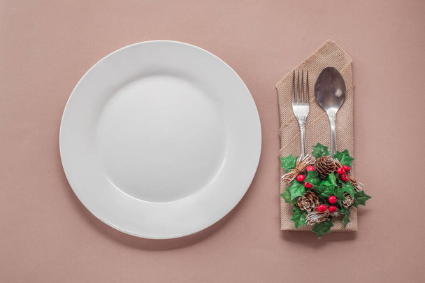 empty white plate and cutlery on pink background, christmas decor, top view, romantic dinner, winter menu - Zdjęcie, obraz
