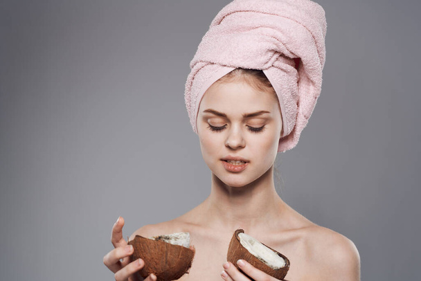 woman with towel on head naked shoulders coconut in hand cropped view gray background - Фото, изображение