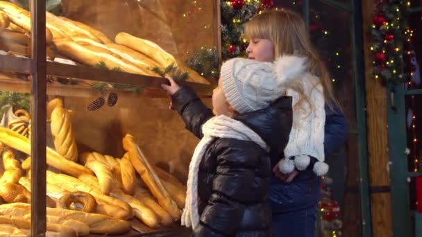 Children choosing bread in bakery in evening - Footage, Video