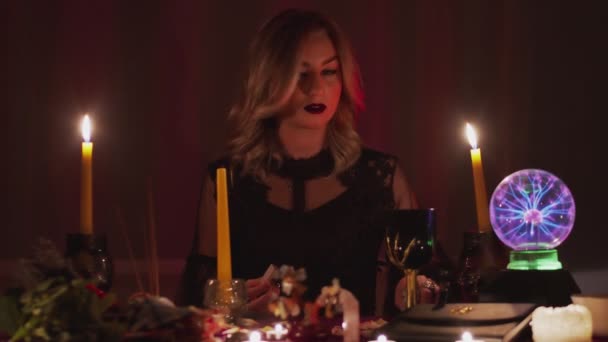 Weibliche Scharlatanin Hexe oder Wahrsagerin zündet keine Kerze für Rituale an - Filmmaterial, Video