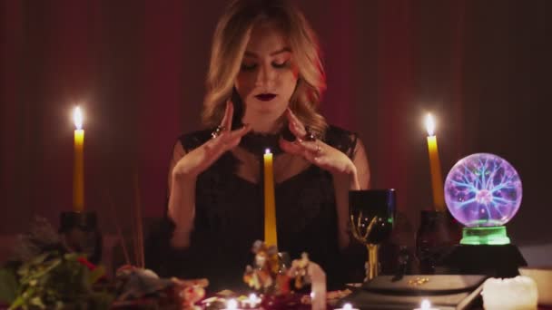Nainen ennustaja liikkuvat kädet yläpuolella taika kynttilä - Materiaali, video