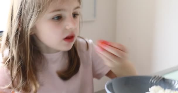 meisje en grappige gezichten en aardbeien taart in de keuken - Video