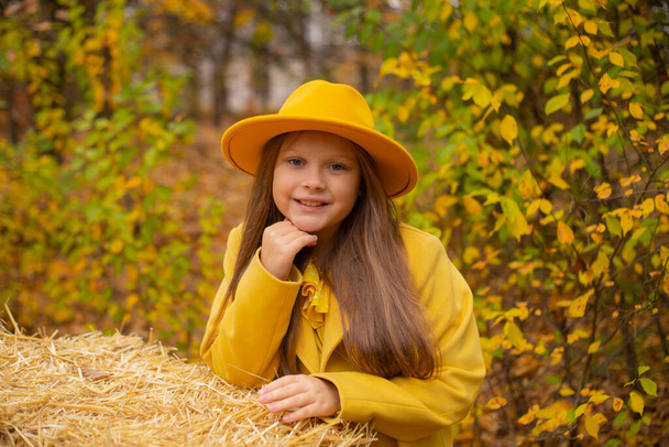 オレンジ色の帽子、ドレス、コートのかわいい十代のブルネットの女の子の肖像画。秋だコズネス.  - 写真・画像
