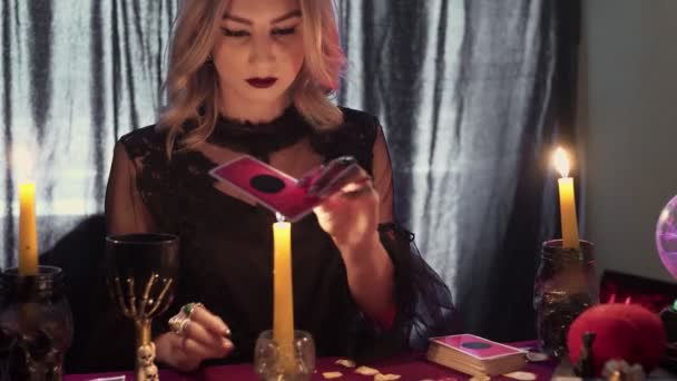 Vrouwelijke waarzegster verplaatst een magische taro kaart over een kaars - Video