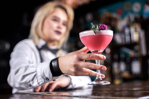 Солодка дівчина бармен показує процес приготування коктейлю в барі
 - Фото, зображення