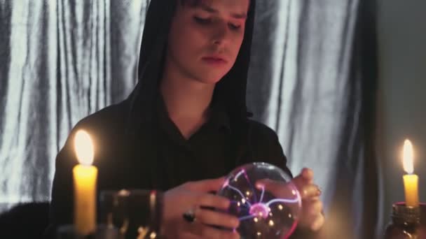 Jonge mannelijke waarzegster die ritueel uitvoert met kristallen bol die de toekomst voorspelt - Video