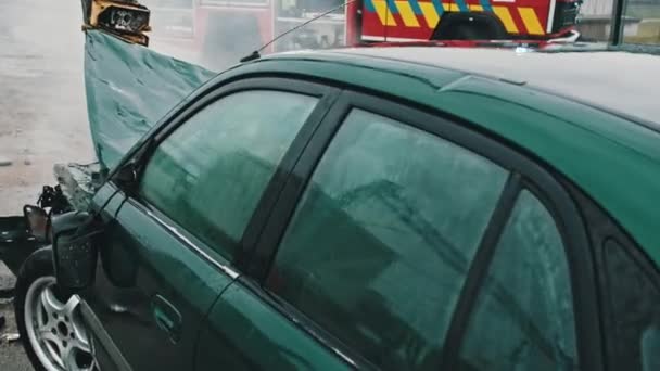Close-up, kapotte auto met brandweerauto op de achtergrond. Auto-ongeluk - Video