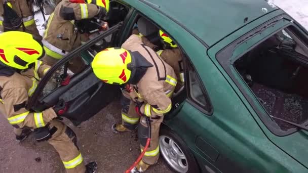 Palomies leikkaa auton ovet hydraulisella leikkurilla. Auto-onnettomuus - Materiaali, video