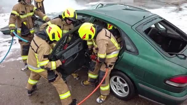 Palomies leikkaa auton ovet hydraulisella leikkurilla. Auto-onnettomuus - Materiaali, video