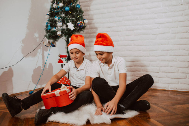 szczęśliwy chłopcy w Santa kapelusze z prezenty świąteczne - Zdjęcie, obraz